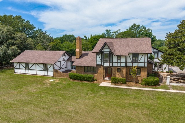 A house with a brown roof and white walls with black trimmings.