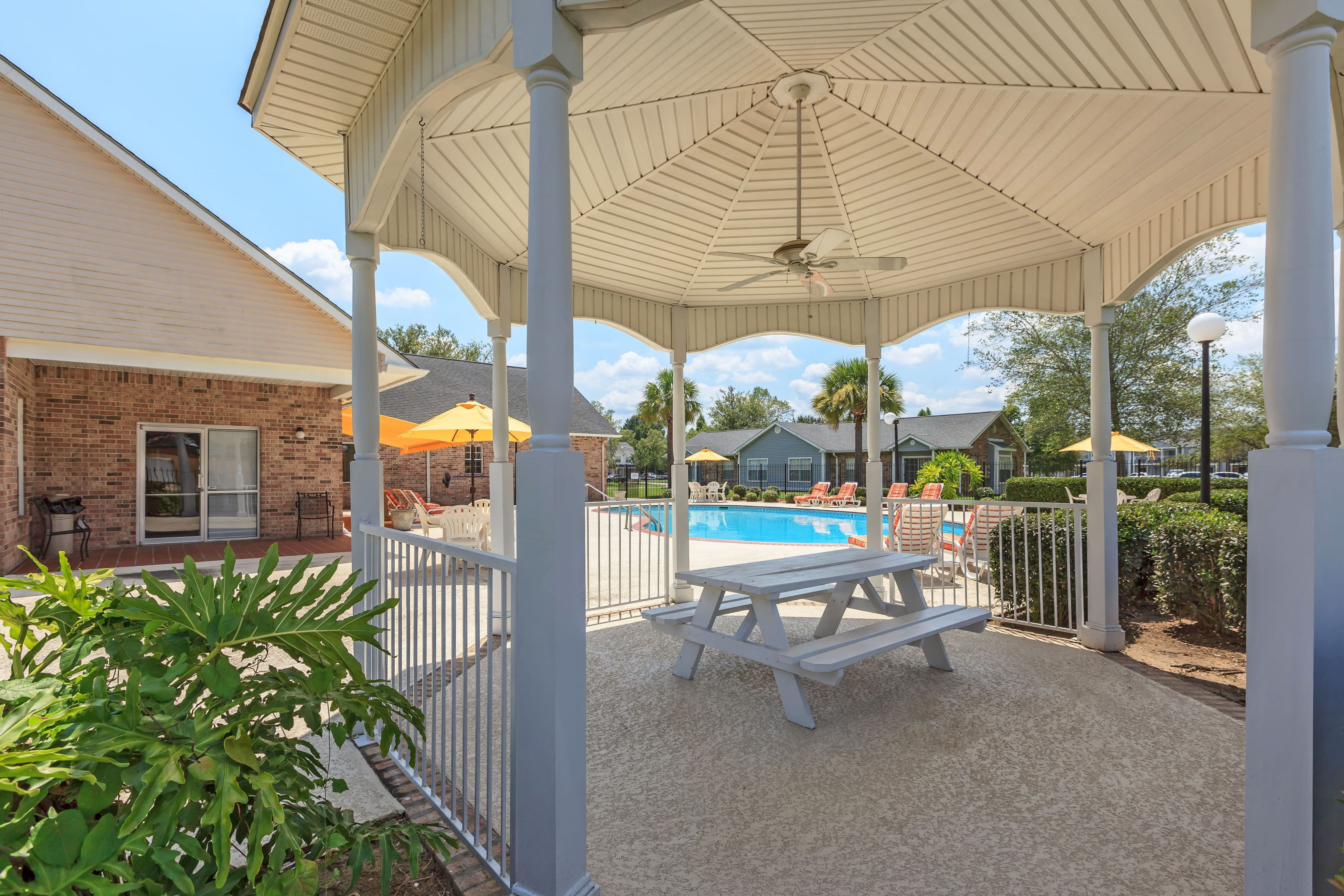 a patio with a picnic table and a swimming pool