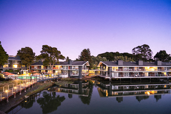 a row of houses on the water at night