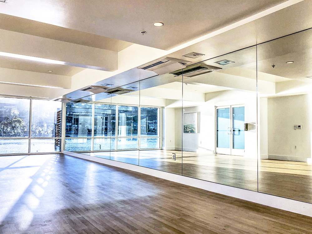a large room with glass walls and a hard wood floor