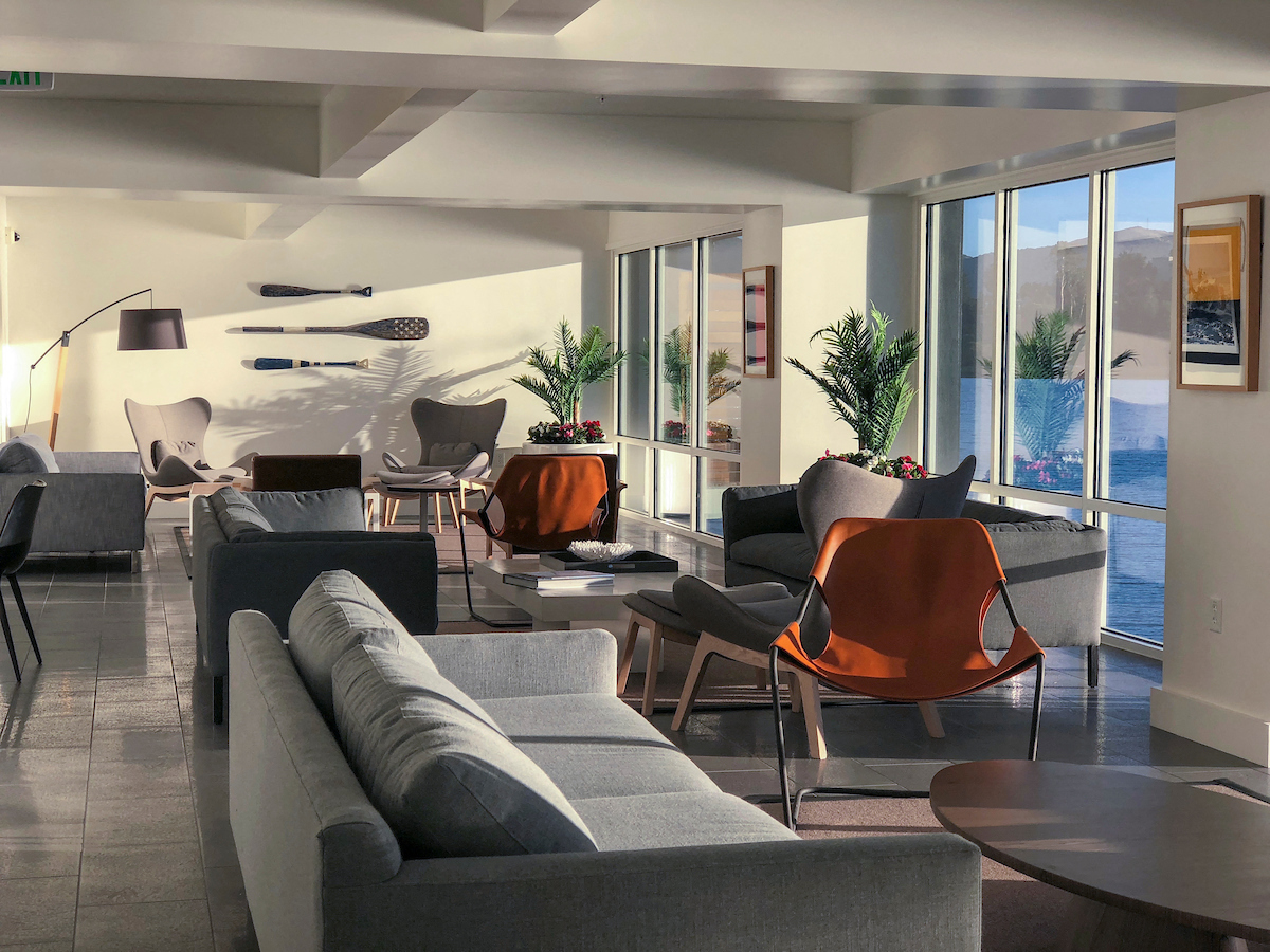 a living room with couches and chairs and a view of the ocean