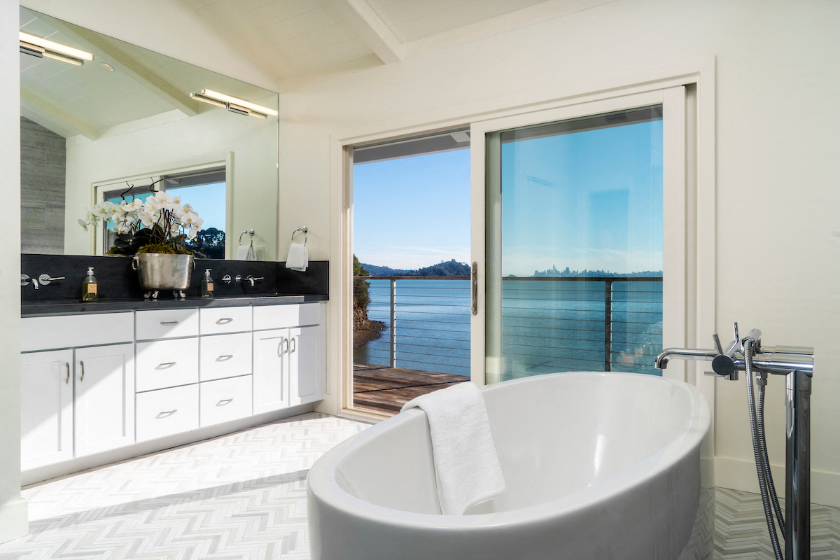 a bathroom with a tub and a view of the water