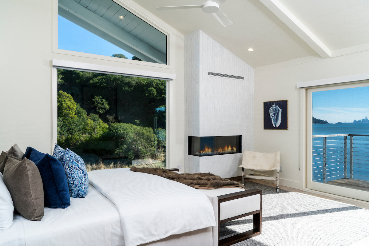 the master bedroom has a fireplace and a view of the ocean