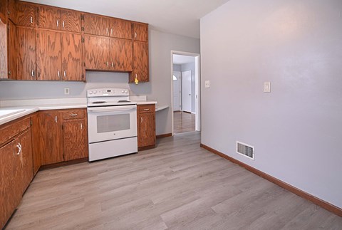 A kitchen with wooden cabinets and a white oven.