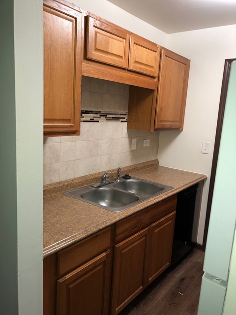 A kitchen with brown cabinets and a sink.