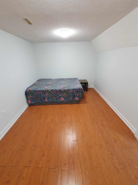 a bedroom with a bed and a wooden floor