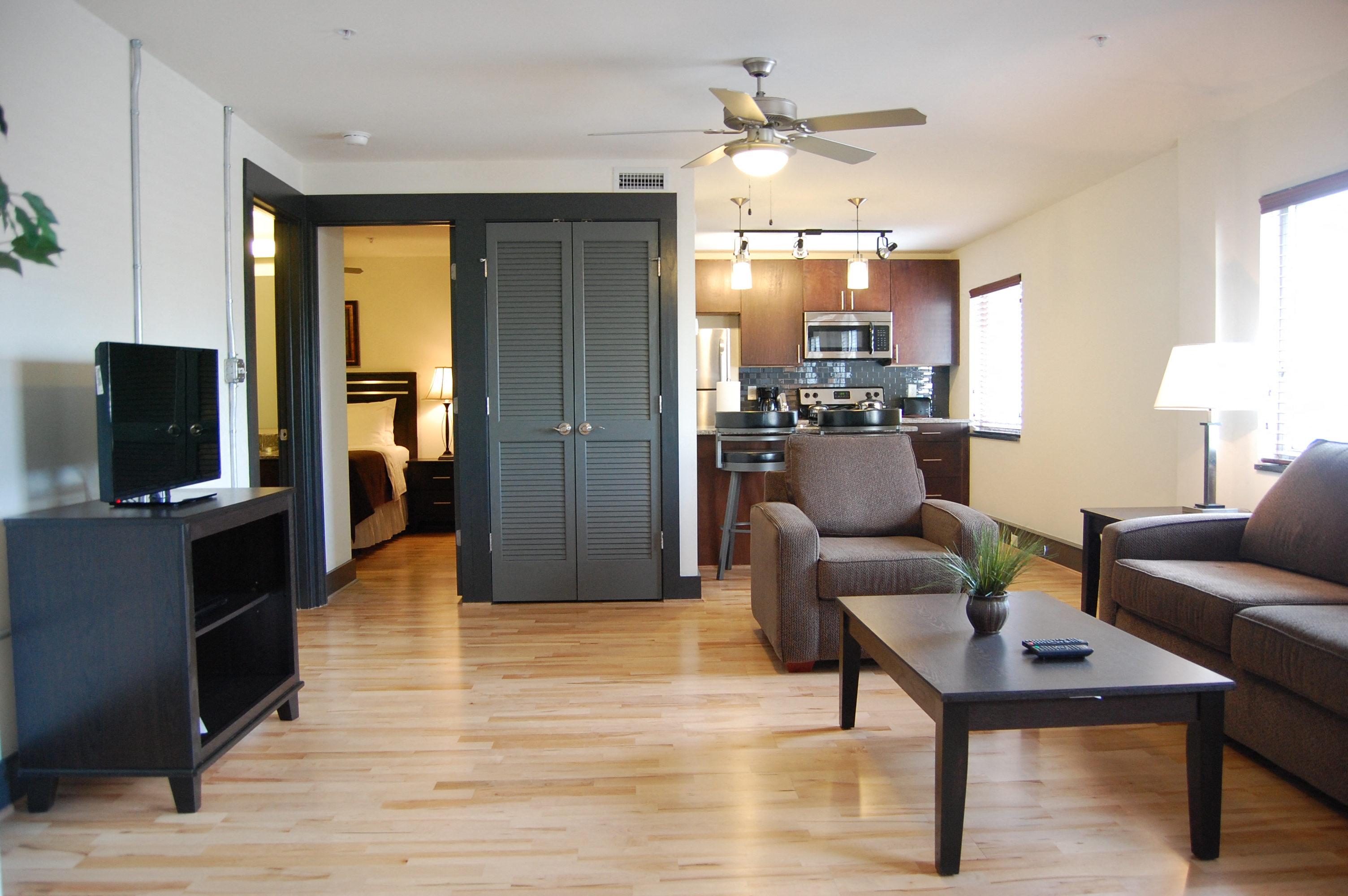 a living room with a couch and a coffee table in front of a kitchen