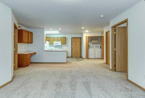 A kitchen area with a counter, cabinets, and a fridge.