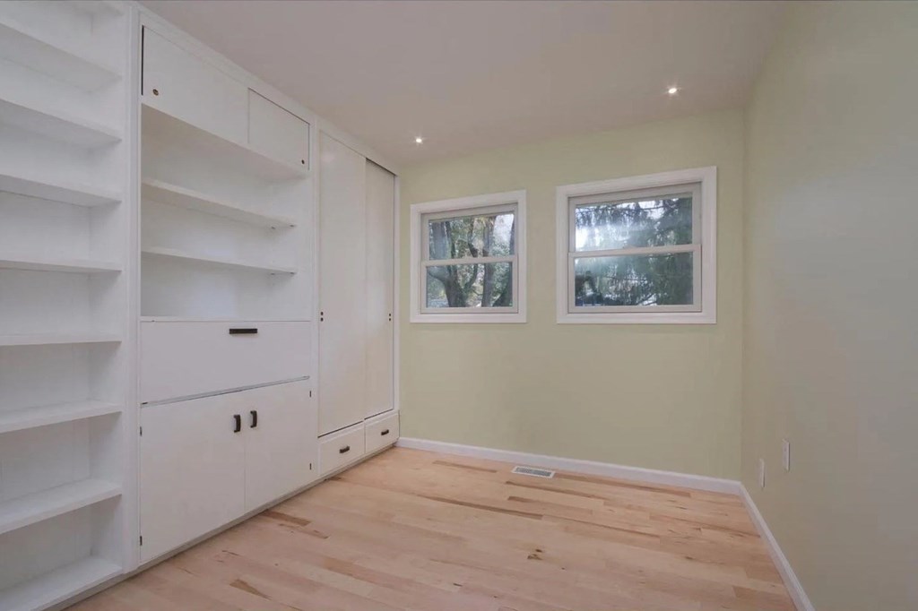 a room with a wooden floor and white closets