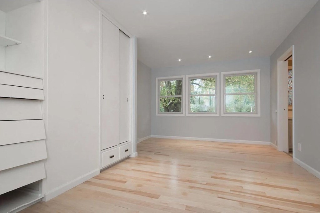 a living room with white cabinets and a wood floor