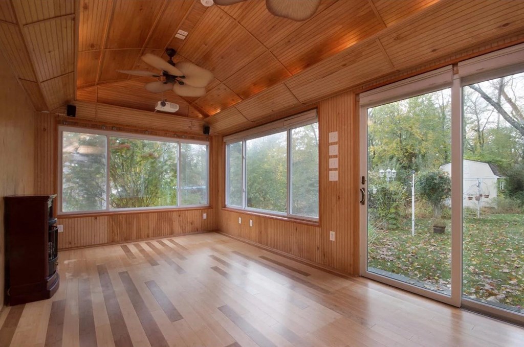 an empty living room with large windows and wooden floors