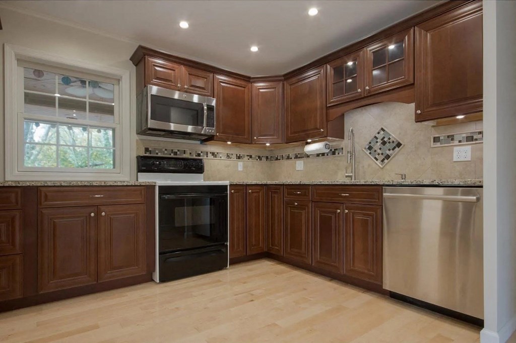 a large kitchen with wooden cabinets and stainless steel appliances