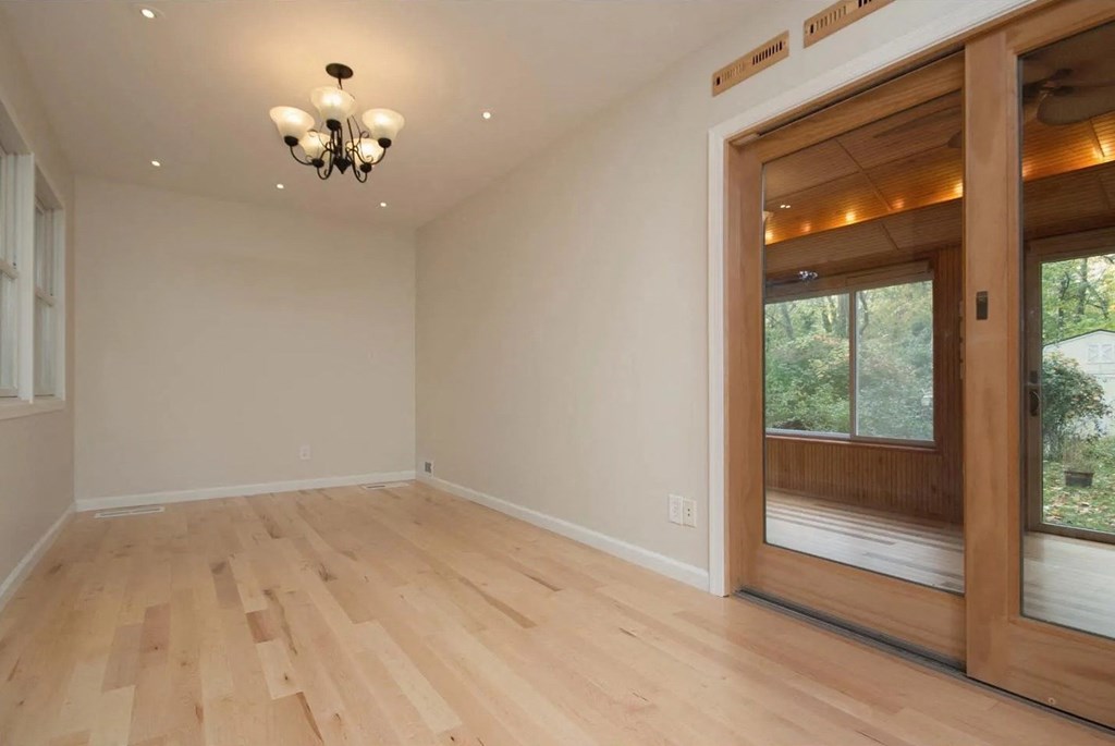 a living room with a wooden floor and a large window