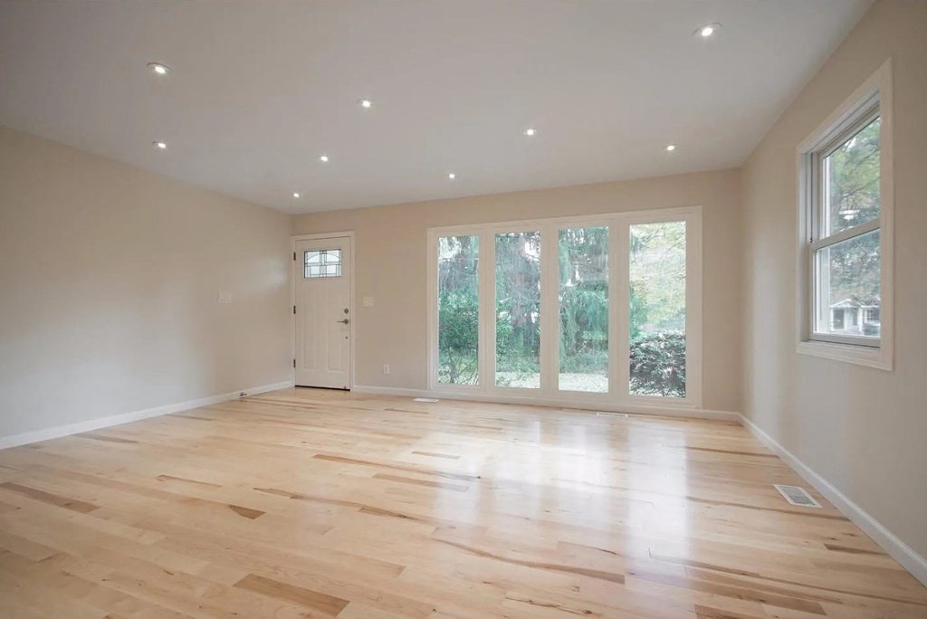 a living room with a hard wood floor and a window