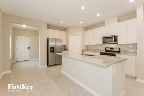 a large kitchen with white cabinets and a counter top