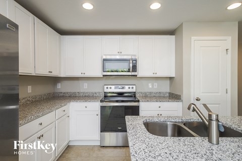 a kitchen with white cabinets and granite counter tops