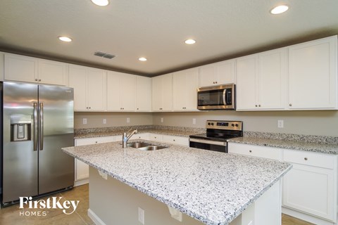 A kitchen with granite countertops and stainless steel appliances.