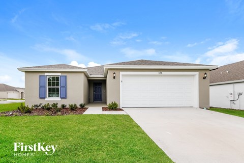 A house with a garage and a driveway in front of it.
