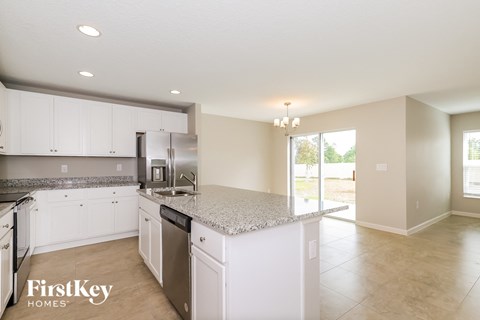 A kitchen with white cabinets and a granite countertop.
