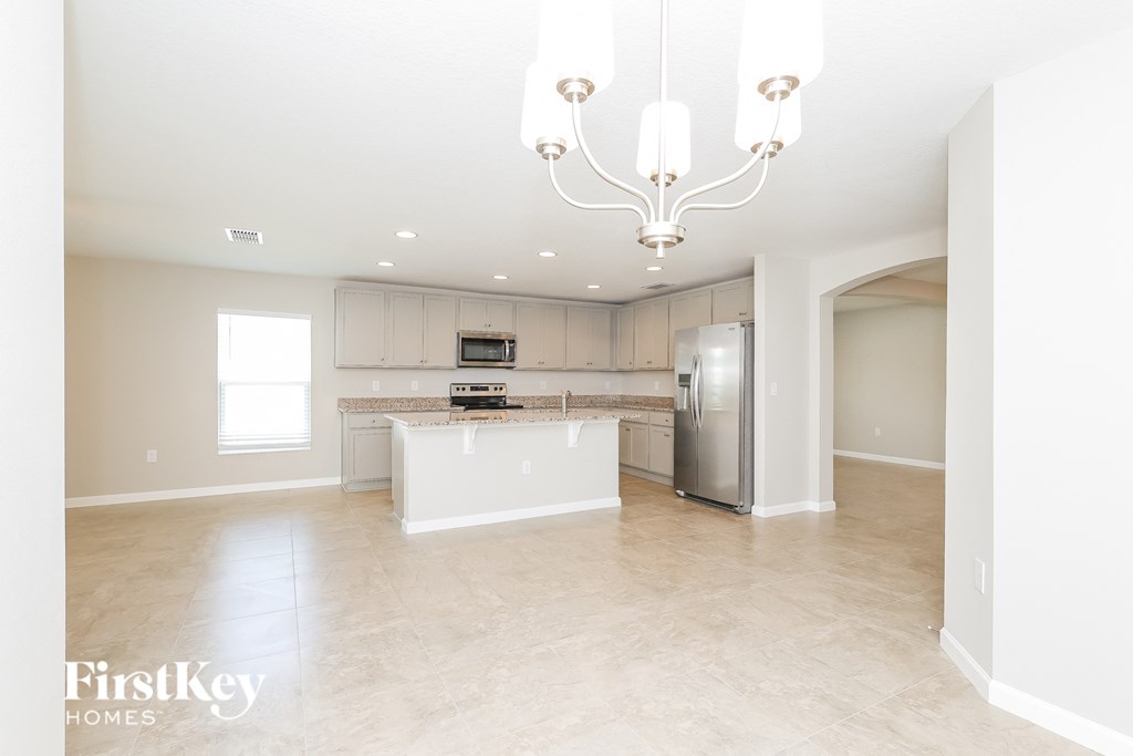 a large kitchen with stainless steel appliances and white cabinets