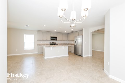 a large kitchen with stainless steel appliances and white cabinets