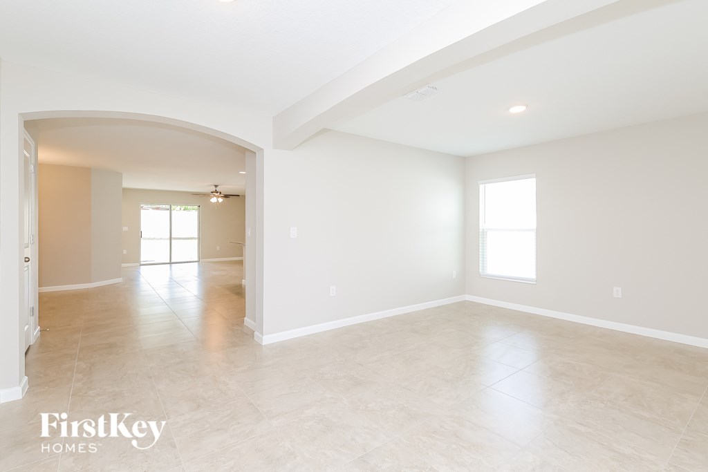 the spacious living room and dining room with the kitchen in the background