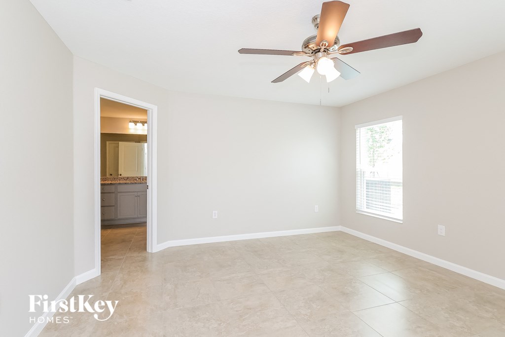 a clean and empty living room with a ceiling fan