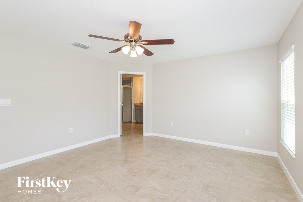 a clean and empty living room with a ceiling fan
