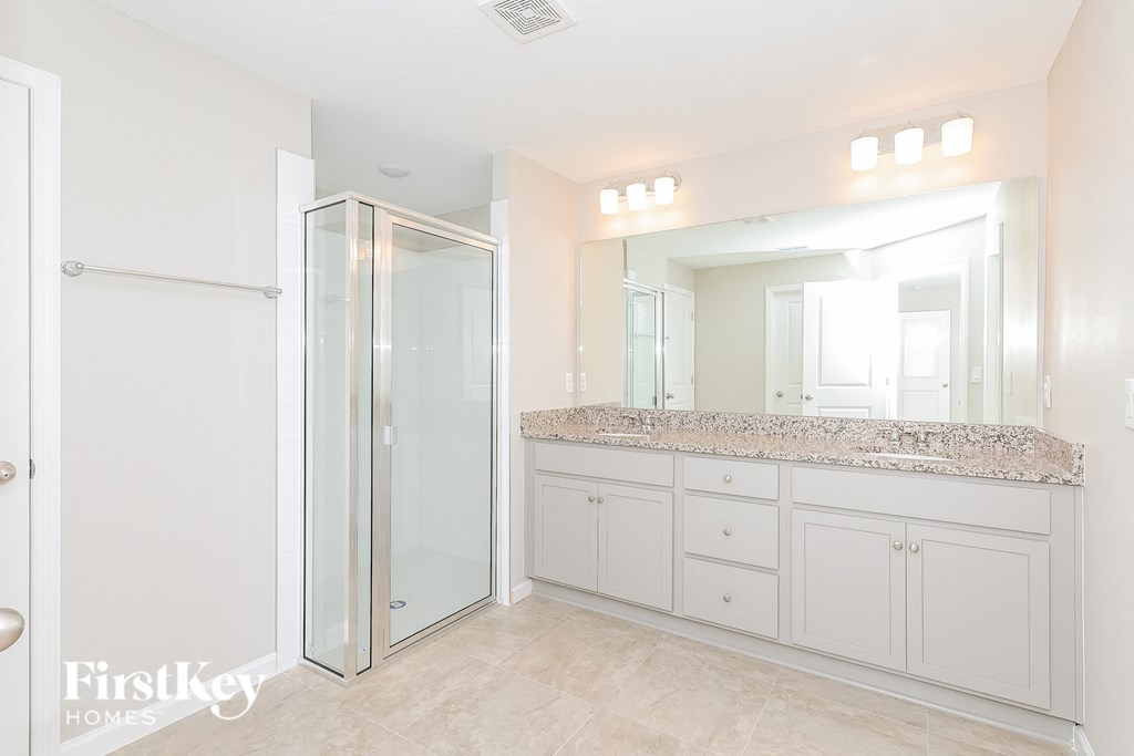 a large white bathroom with a large shower and sink