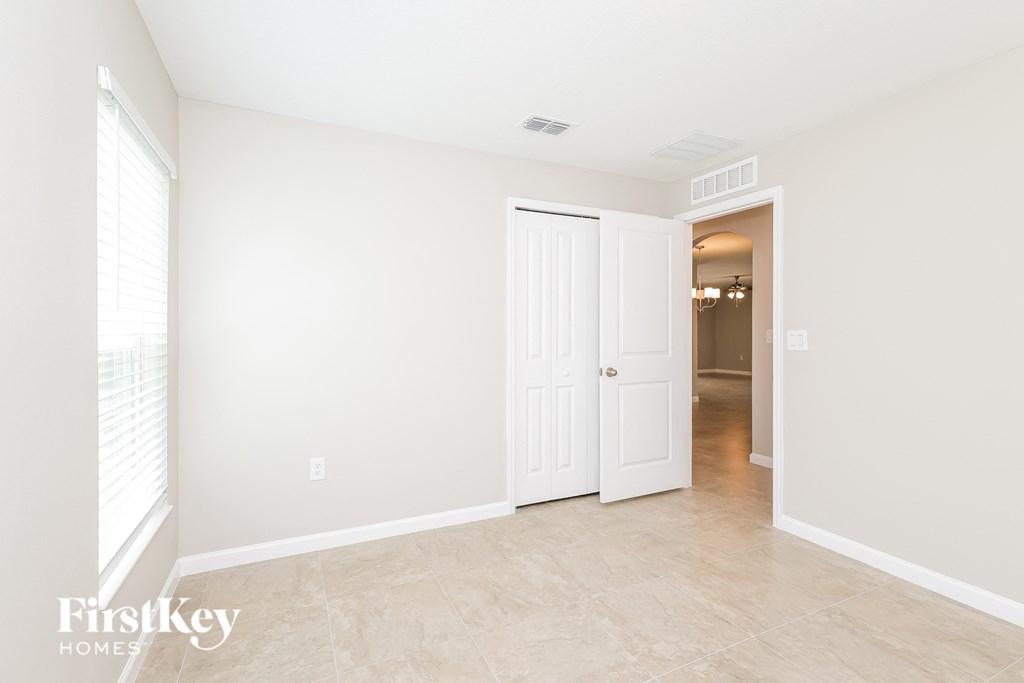a living room with a white door and a hallway with a door to a closet
