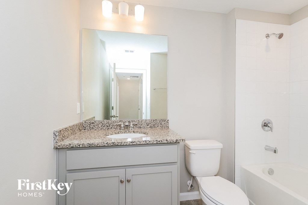 a bathroom with a sink toilet and a mirror
