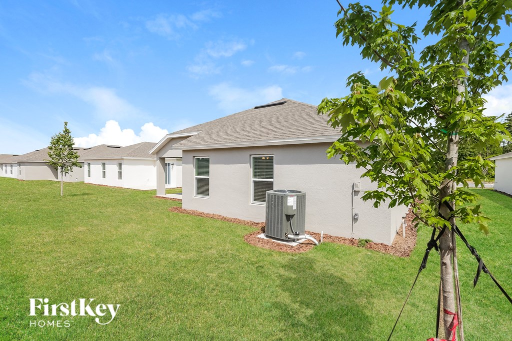 a backyard with a house and a green lawn