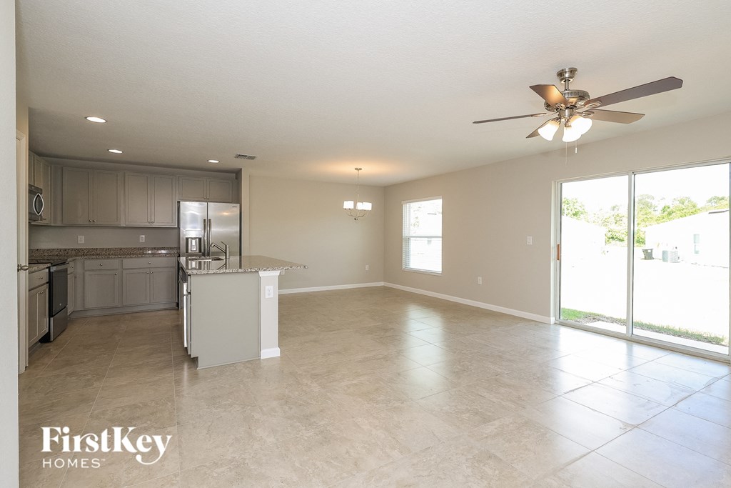 an empty kitchen and living room with a ceiling fan