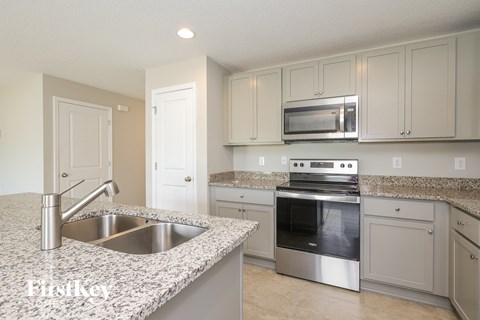 a kitchen with granite counter tops and white cabinets