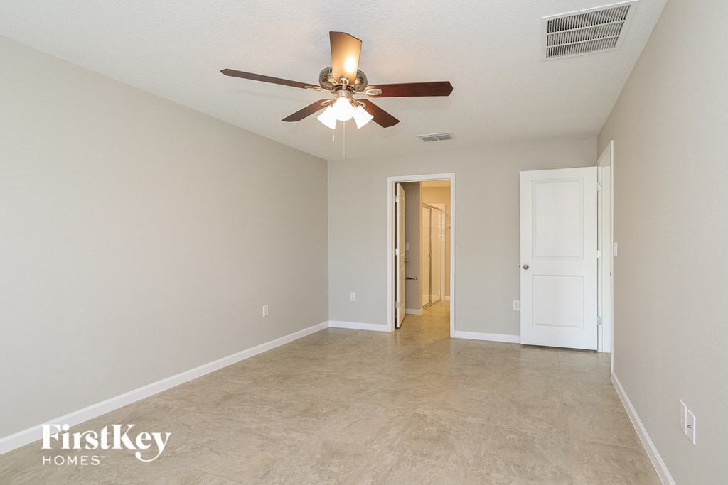 the spacious living room with ceiling fan and tile flooring
