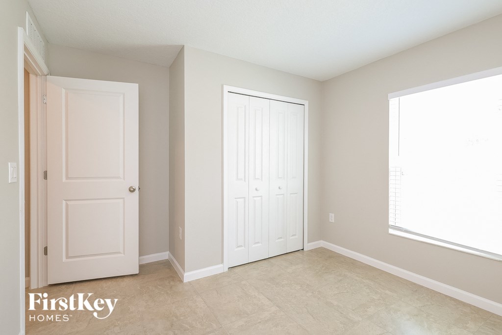 an empty room with two doors and a window