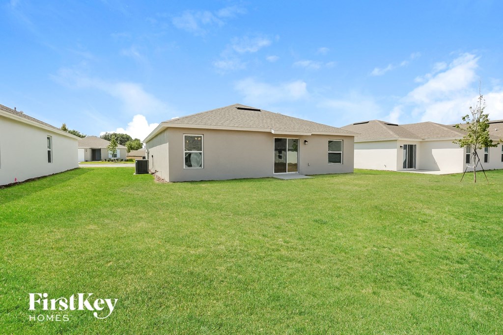 a backyard with a house and a green lawn