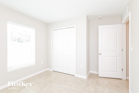 a bedroom with two white doors and a tiled floor