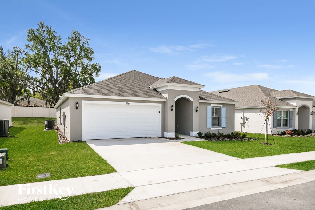 a white house with a garage and a lawn