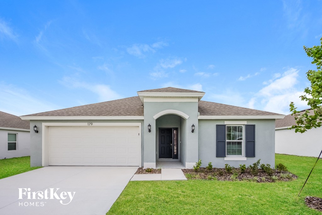 a white house with a garage door and a driveway