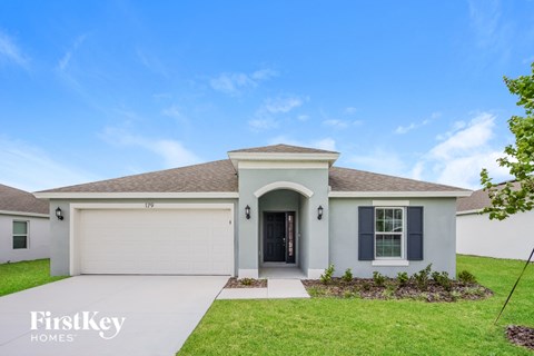 a white house with a garage door and a driveway