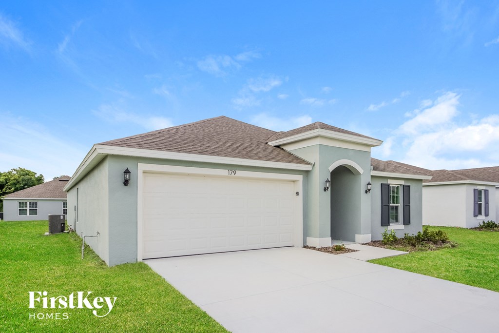 a beige house with a garage and a driveway