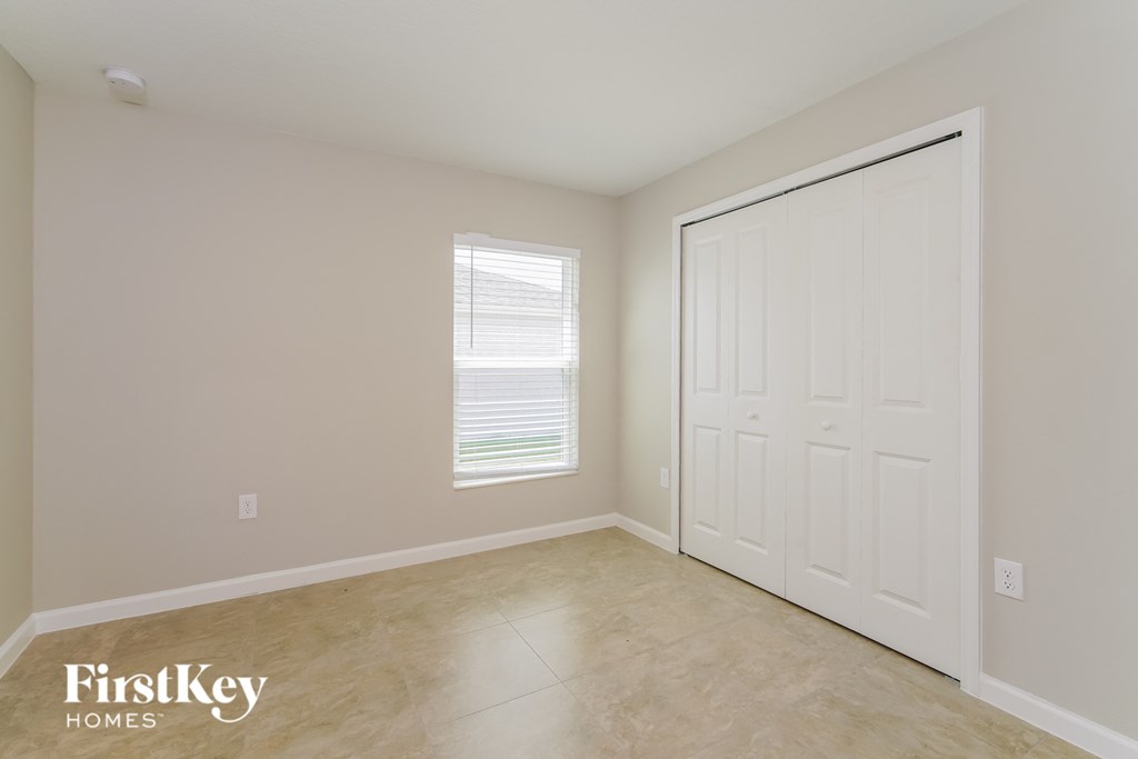 an empty room with a white door and a window