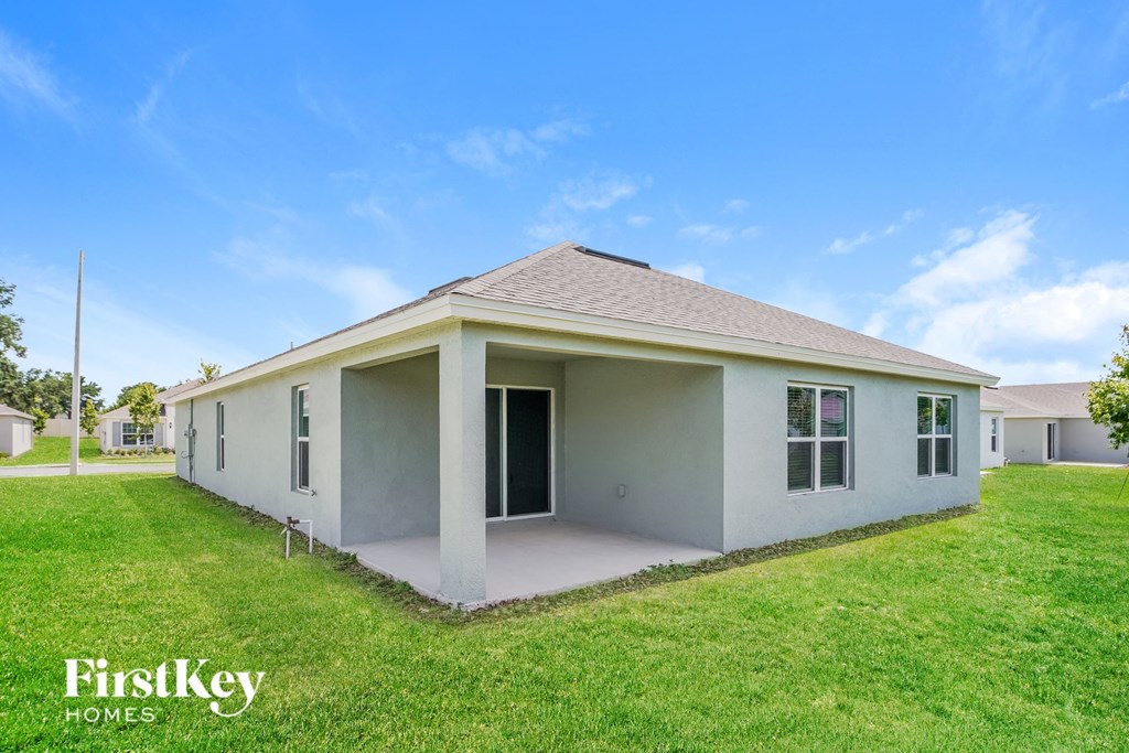 a small white house with a lawn and a blue sky