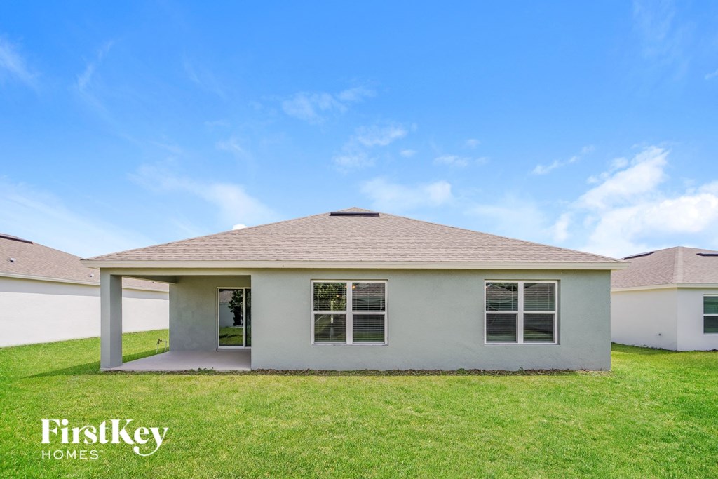 a small house with a lawn and a blue sky