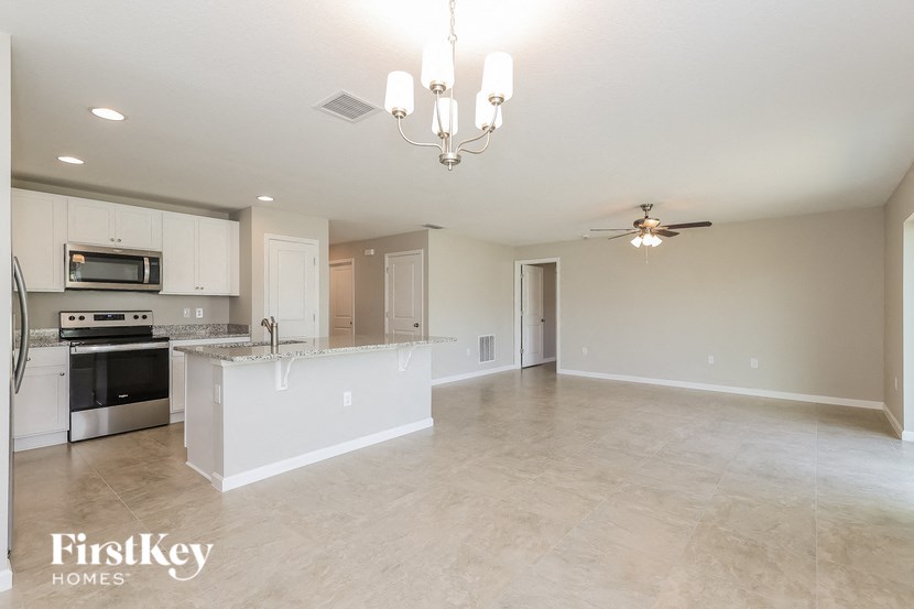 an empty kitchen and living room with a counter top