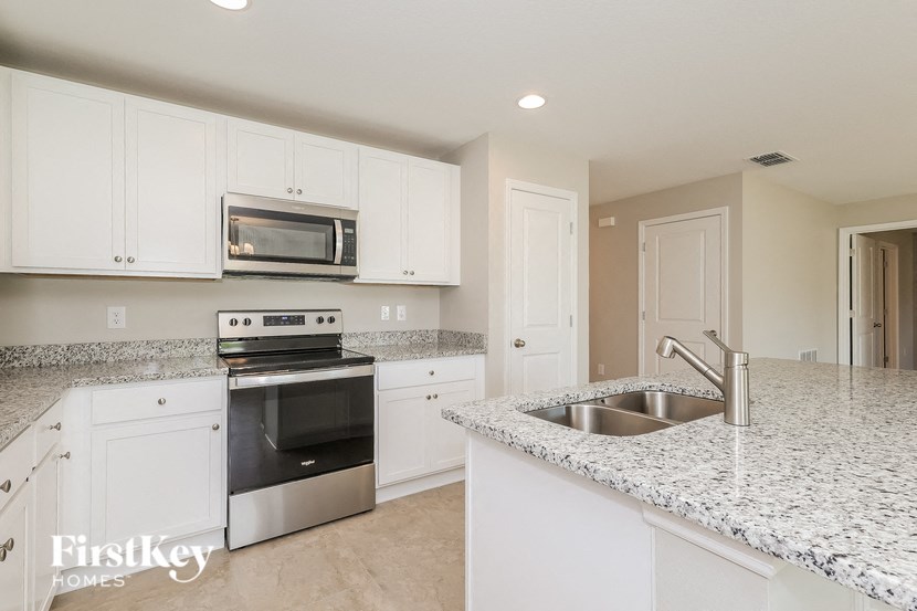 a kitchen with granite counter tops and white cabinets
