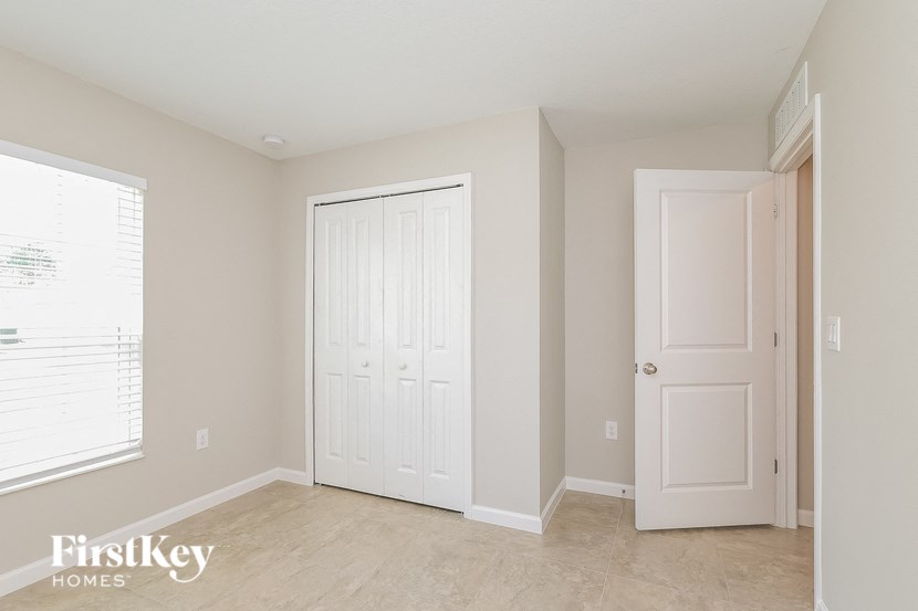 an empty bedroom with a white door and a window