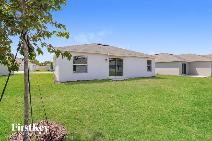 a white house with a yard and a tree