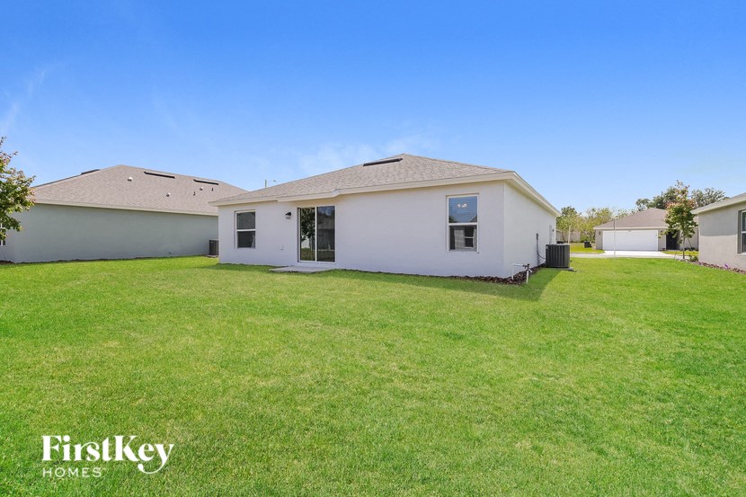 a white house with a green lawn and a blue sky